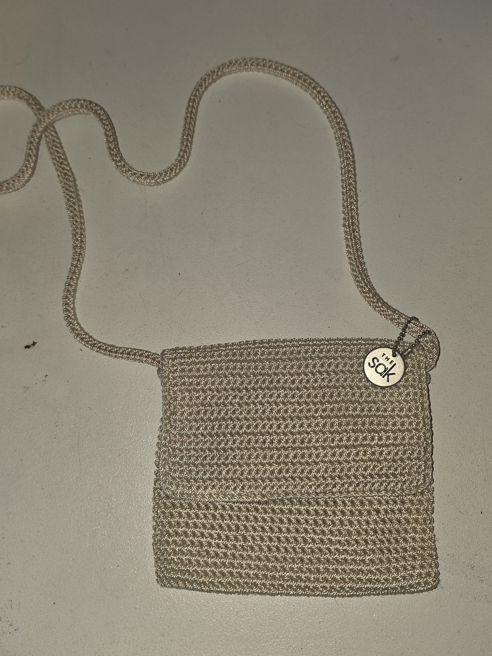 The Sak Tan Crochet Crossbody Bag with Logo Charm